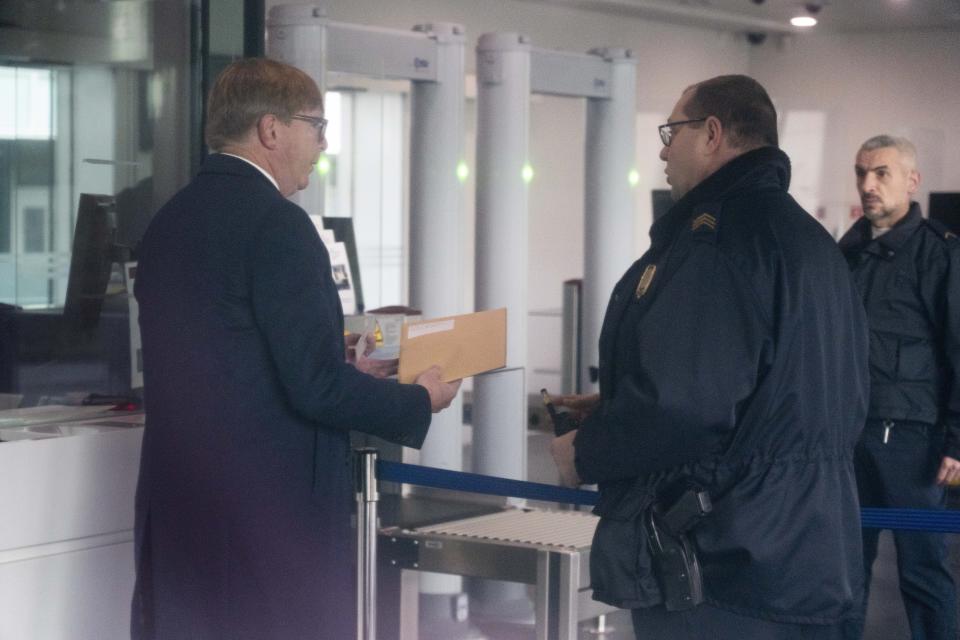 Rodney Dixon, lawyer for Al Jazeera, talks to security officers at the International Criminal Court in The Hague, Netherlands, Tuesday, Dec. 6, 2022, holding a letter requesting a formal investigation into the fatal shooting of Al Jazeera journalist Shireen Abu Akleh. Palestinian officials, Abu Akleh's family and Al Jazeera accuse Israel of intentionally targeting and killing the 51-year-old journalist, a claim Israel denies. (AP Photo/Peter Dejong)