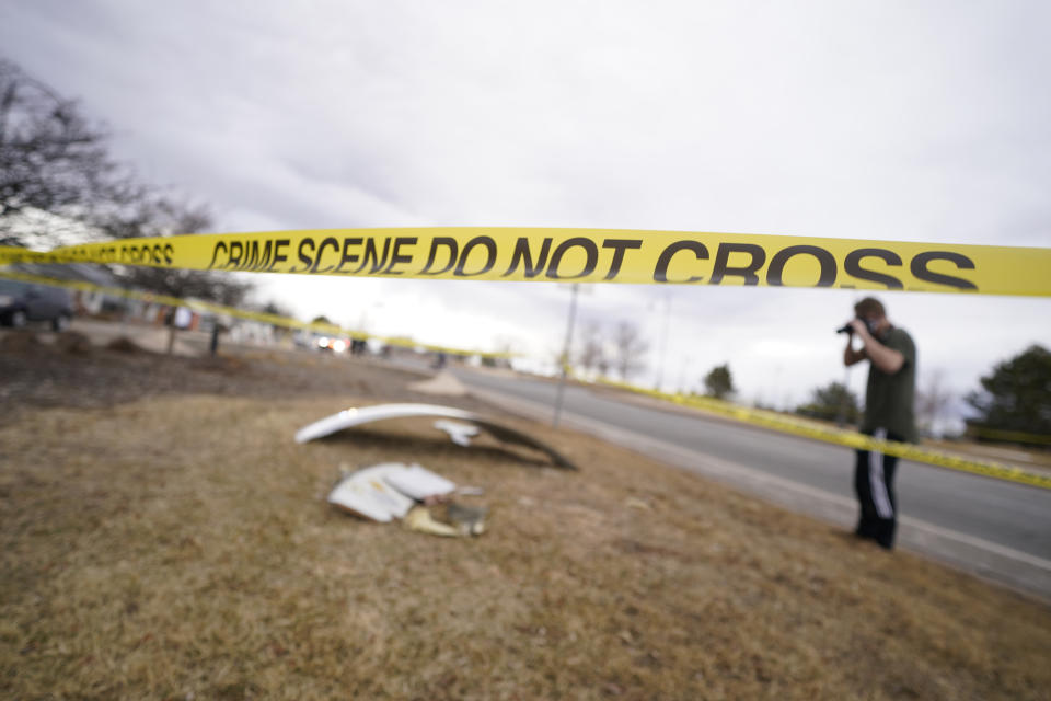 People look over debris that fell off a plane that shed parts over a neighborhood in Broomfield, Colo., Saturday, Feb. 20, 2021. The plane was making an emergency landing at nearby Denver International Airport. (AP Photo/David Zalubowski)