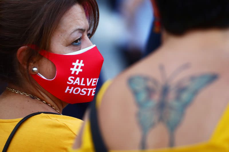 A demonstrator wears protective face masks reading "Save the hostelry sector" as she attends a protest in Madrid