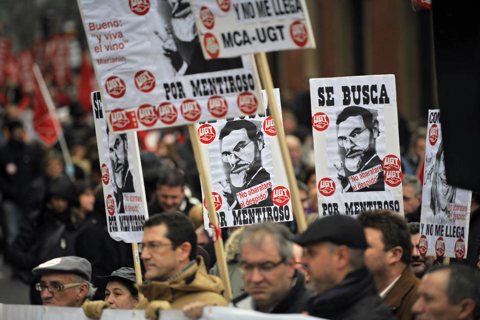 People hold placards with cartoons of the Spanish Primer Minister Mariano Rajoy and Maria Dolores de Cospedal reading: '' Wanted for Liar '' as they protest against the economic policy of the Conservative Spanish Government during a rally in Pamplona, northern Spain, Sunday, Feb. 19, 2012. The new conservative Popular Party government pledges new labor reforms to try to halt further job destruction as Spain already has the highest unemployment rate in the 17-nation eurozone with more than five millions unemployed and more than eleven million people are poor and at risk of social exclusion, by the strong economic crisis. (AP Photo/Alvaro Barrientos)