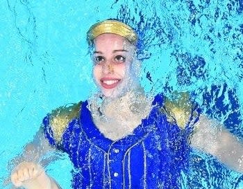 Close-up of one swimmer, her face barely out of the water, but smiling and eyes wide open