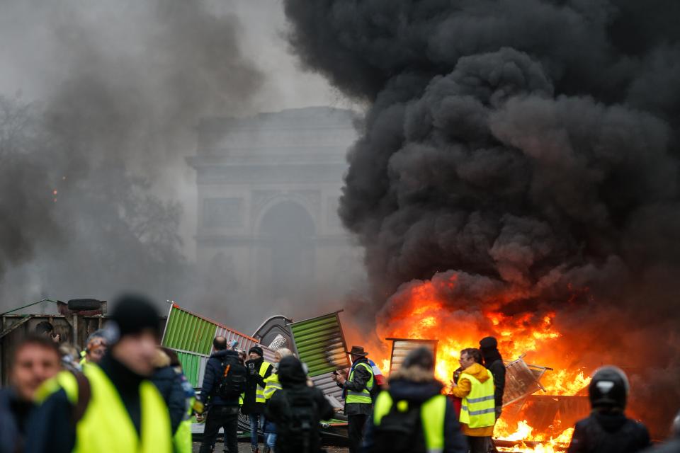 <p>Face à la hausse du prix des carburants et à la baisse du pouoir d’achat, de nombreux automobilistes se retrouvent, munis de leur gilet jaune, le 17 novembre pour des opérations de blocage à travers toute la France. Le mouvement, lancé sur les réseaux sociaux, n’est pas structuré et n’est lié à aucun parti politique ou syndicat. La première journée de mobilisation réunit 282 000 personnes dans tout le pays e connaît de nombreuses scènes de heurts. Plusieurs agressions ont été recensées et deux personnes ont perdu la vie. La semaine suivante, pour “l’acte 2″, de nouvelles scènes de violence, principalement à Paris, se produisent. Malgré le filtrage sur les Champs-Élysées le 1er décembre pour l’”acte 3”, des manifestants violents y accèdent. L’Arc de Triomphe est saccagé, des voitures ainsi que des barricades de fortune sont incendiées. Plus de 400 personnes sont interpellées. Malgré les scissions au sein du mouvement, de nombreux gilets jaunes modérés appelant à la fin des violences et des dégradations, un acte 4 est programmé. Les forces de l’ordre sont mobilisées en masse et procèdent à 2000 interpellations dans toute la France. Silencieux depuis le début du mouvement, Emmanuel Macron s’exprime au surlendemain de cette quatrième journée de mobilisation et fait plusieurs annonces en faveur du pouvoir d’achat (hausse du SMIC de 100€ via la prime d’activité, défiscalisation des heures supplémentaires, suspension de la hausse de la CSG pour les plus petites retraites). Malgré cela, l’appel à un acte 5 est maintenu pour le 15 décembre. Une nouvelle journée de manifestation qui sera plus calme que les précédentes.<br>(Crédit Geoffroy VAN DER HASSELT / AFP) </p>