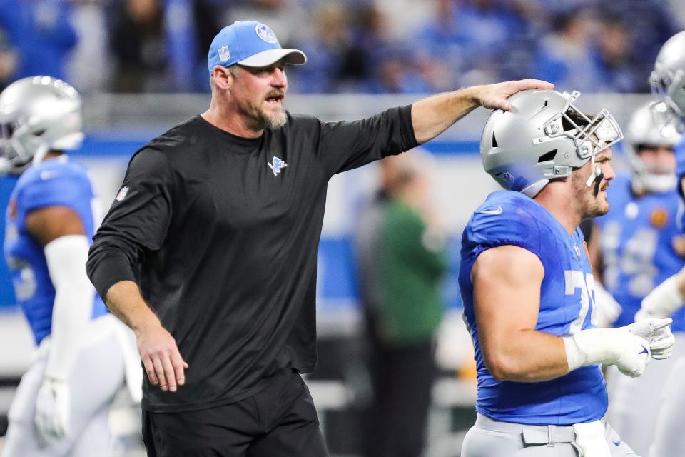 Detroit Lions head coach Dan Campbell talks to defensive end John Cominsky during warmups before the game against the Green Bay Packers at Ford Field in Detroit on Thursday, Nov. 23, 2023.