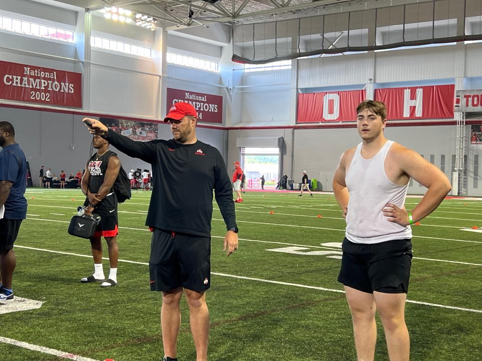 Ohio State 2024 offensive line commit Ian Moore stands next to offensive line coach Justin Frye as he times 40-yard dashes as the Buckeyes' recruiting camp.