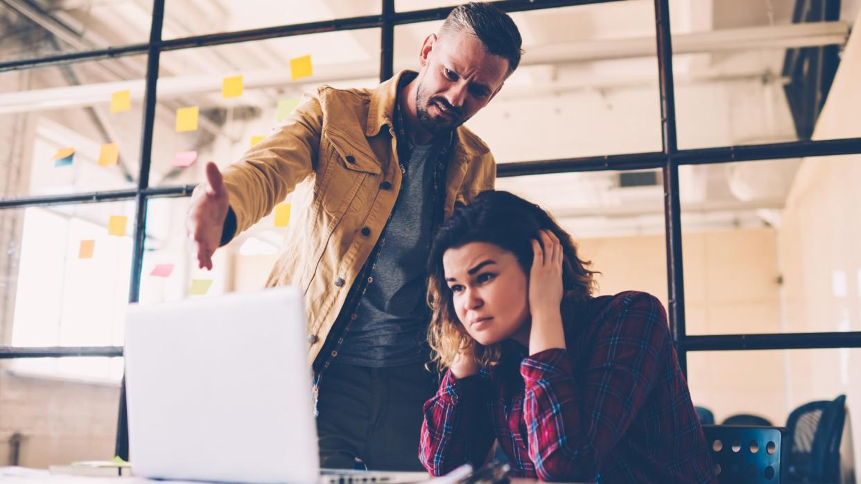 Female student feeling upset with project failure listening to coach critics during meeting in office, irritated leader of company checking work of employee angry about bad ideas and accountings - Image.