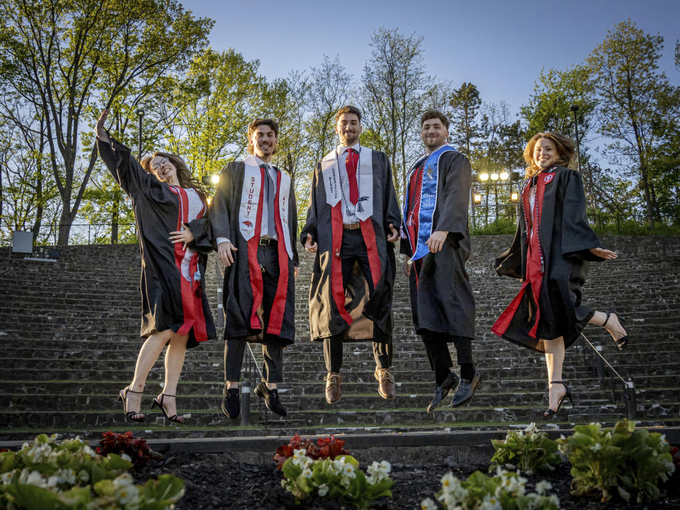 The Povolos quintuplets, from left; Ashley, Michael, Marcus, Ludovico, and Victoria jump for a photo on commencement day at the Montclair State University, Monday, May 13, 2024, in Montclair, N.J. (Mike Peters/Montclair State University via AP)