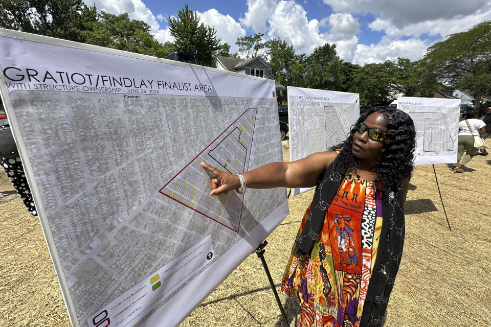 Donna Anthony, 63, points to a map of her neighborhood that was chosen to receive solar arrays, Monday, Jun 24, 2024, in east Detroit. The arrays would produce enough clean energy to offset the electricity used currently by 127 municipal buildings. Residents will receive funding to make their homes energy efficient. (AP Photo/Corey Williams)