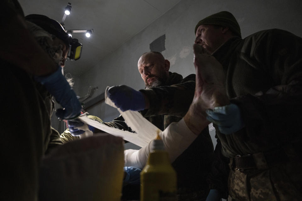 Ukrainian military doctors treat their injured comrade who was evacuated from the battlefield at the hospital in Donetsk region, Ukraine, Monday, Jan. 9, 2023. The serviceman did not survive. (AP Photo/Evgeniy Maloletka)