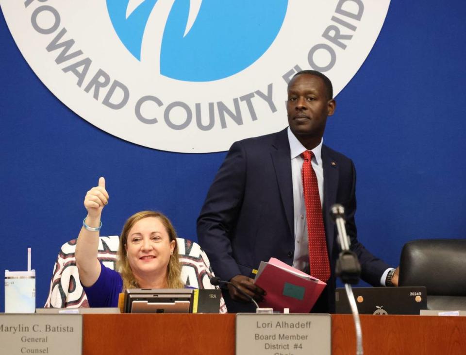 Howard Hepburn, right, walks back to his seat on the dais after being sworn into the office of superintendent of Broward County Public Schools on Wednesday, May 29, 2024, inside the boardroom of the Kathleen C. Wright Administration Center in Fort Lauderdale, Florida. On the left, Broward School Board Chair Lori Alhadeff raises a thumbs-up in the air.