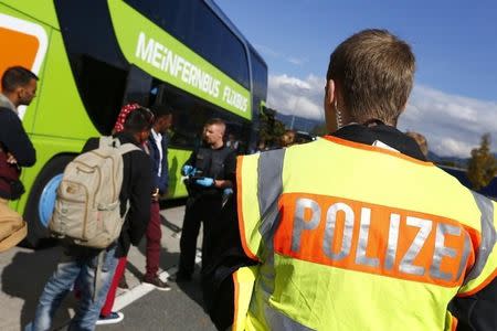 German policemen control passports by bus passengers at a highway rest area near Kiefersfelden close to the A93 highway from Austria to Germany, southern Germany, October 9, 2015. REUTERS/Michaela Rehle