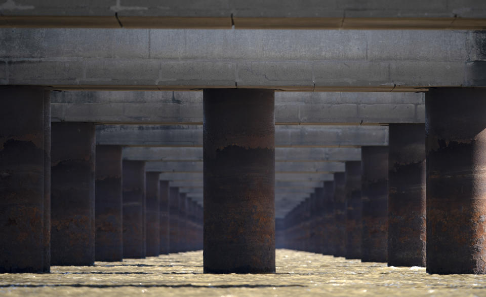 The pillars of the massive Rosario-Victoria Bridge are exposed during a drought affecting the Parana River near Rosario, Argentina, Thursday, July 29, 2021. At the port city of Santa Fe the river registered a level of 22 centimeters, the lowest in 50 years. (AP Photo/Victor Caivano)