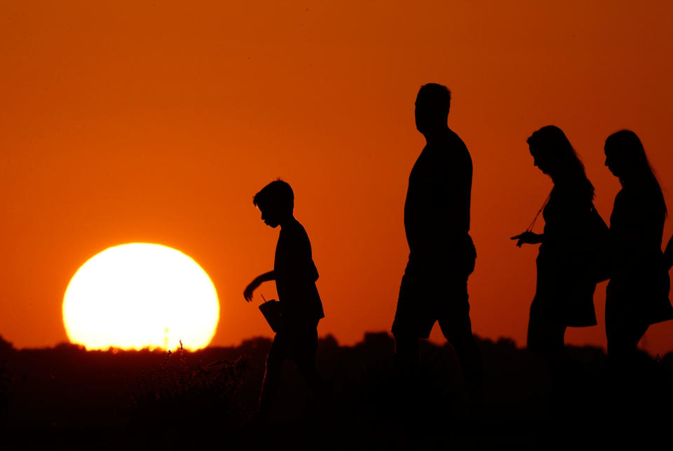 <p>The sun sets beyond visitors to Liberty Memorial as the temperature hovers around 100 degrees in Kansas City, Mo., July 21, 2016. It’s as if Hillary Clinton and Donald Trump live on two entirely different Earths: one warming, one not. Clinton says climate change “threatens us all,” while Trump tweets that global warming is “mythical” and repeatedly refers to it as a “hoax.” Measurements and scientists say Clinton’s Earth is much closer to reality. (AP Photo/Charlie Riedel) </p>