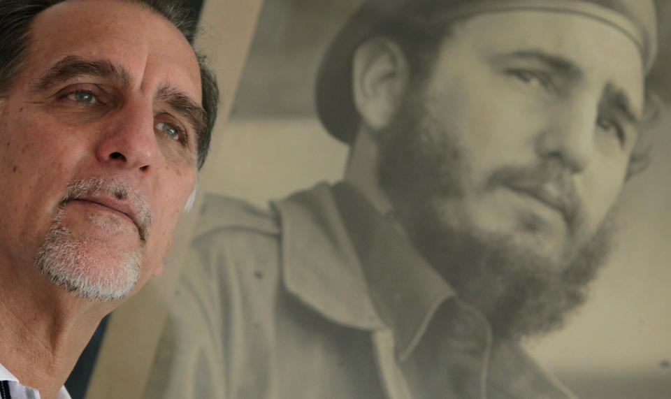In this Feb. 17, 2014 photo, Rene Gonzalez, the “Cuban Five," poses for a portrait under a framed picture of Fidel Castro in Havana, Cuba. Gonzalez was an unknown young pilot in 1990 when he pretended to steal a crop duster in Cuba and flew to Florida, using cover as a Cuban defector to spy on targets in the United States. The Cuba Five refers to intelligence agents in the employ of Fidel Castro's Cuba, they were arrested in the United States in 1998 and given terms ranging from 15 years to consecutive life sentences on charges including conspiracy and failure to register as foreign agents. (AP Photo/Franklin Reyes)