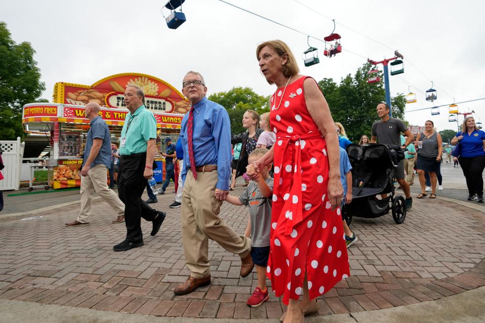 Gov. Mike DeWine and his wife, Fran, walk through the food highway with their grandson, Tad, and numerous other family members during the opening day of the Ohio State Fair.