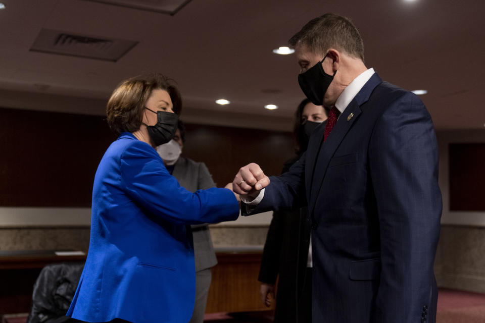 Chairwoman Sen. Amy Klobuchar, D-Minn., left, speaks with former U.S. Capitol Police Chief Steven Sund, right, following a Senate Homeland Security and Governmental Affairs & Senate Rules and Administration joint hearing on Capitol Hill, Washington, Tuesday, Feb. 23, 2021, to examine the January 6th attack on the Capitol. (AP Photo/Andrew Harnik, Pool)