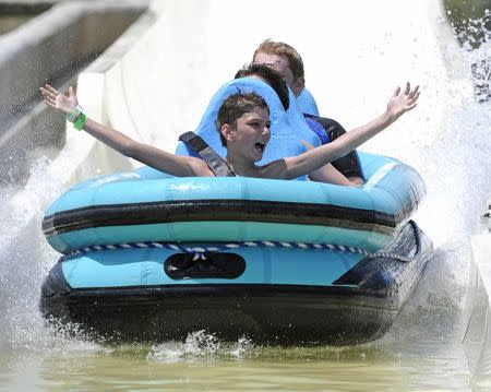 Cory Schiffman, from Boston, celebrates as he comes in for a landing after riding the Verruckt waterslide during its public opening at the Schlitterbahn Waterpark in Kansas City, Kansas July 10, 2014. REUTERS/Dave Kaup