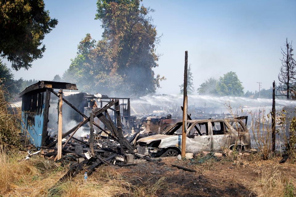 The smoldering remains of Chris Beltran’s car and house continue to be hosed down after a fire destroyed two homes on Kremont Avenue.