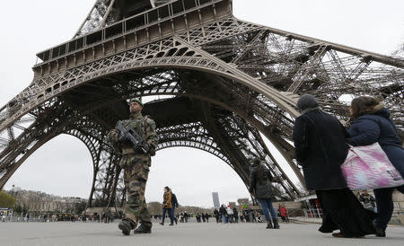 French soldiers patrol near the Eiffel Tower as part of the highest level of "Vigipirate" security plan after a shooting at the Paris offices of Charlie Hebdo January 12, 2015. France will deploy 10,000 soldiers on home soil by Tuesday and post almost 5,000 extra police officers to protect Jewish sites after the killing of 17 people by Islamist militants in Paris last week, officials said. REUTERS/Gonzalo Fuentes (FRANCE - Tags: CRIME LAW POLITICS MILITARY TPX IMAGES OF THE DAY) - RTR4L4DR