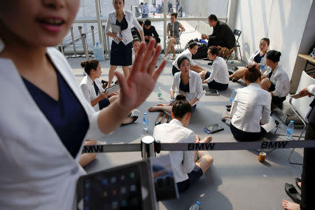 Hostesses rest during the Auto China 2016 auto show in Beijing, China, April 29, 2016. REUTERS/Damir Sagolj/File Photo