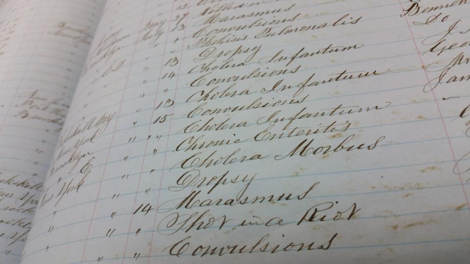 Archives recording burials at Green-Wood Cemetery from July 1863, which show causes of death including cholera and "shot in a riot," which Lisa Alpert, vice president of development and programming for Green-Wood Cemetery, says is a reference to the Civil War Draft Riots. (Photo: Handout/ Lisa Alpert)