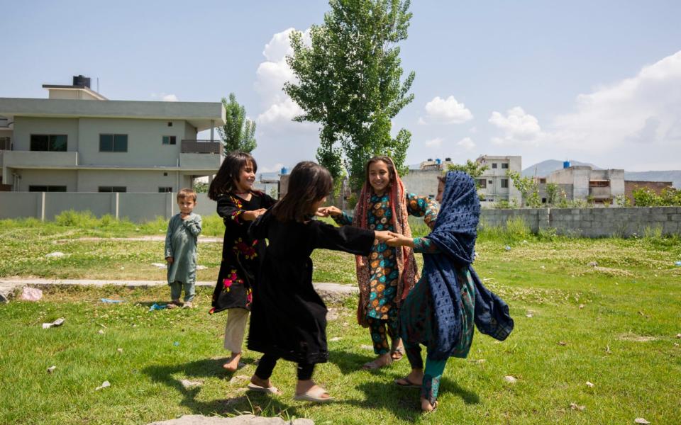 Children dance with joy under blue skies - Saiyna Bashir for the Telegraph