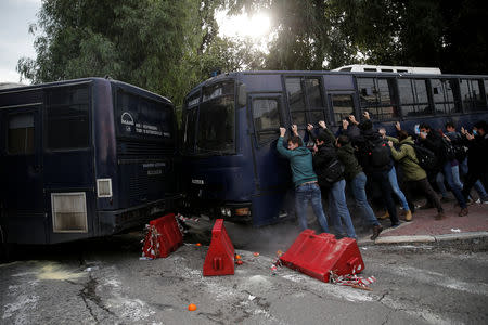 Protesters push a police bus as Greek school teachers scuffle with riot police during a demonstration against government plans to change hiring procedures in the public sector in Athens, Greece, January 11, 2019. REUTERS/Costas Baltas