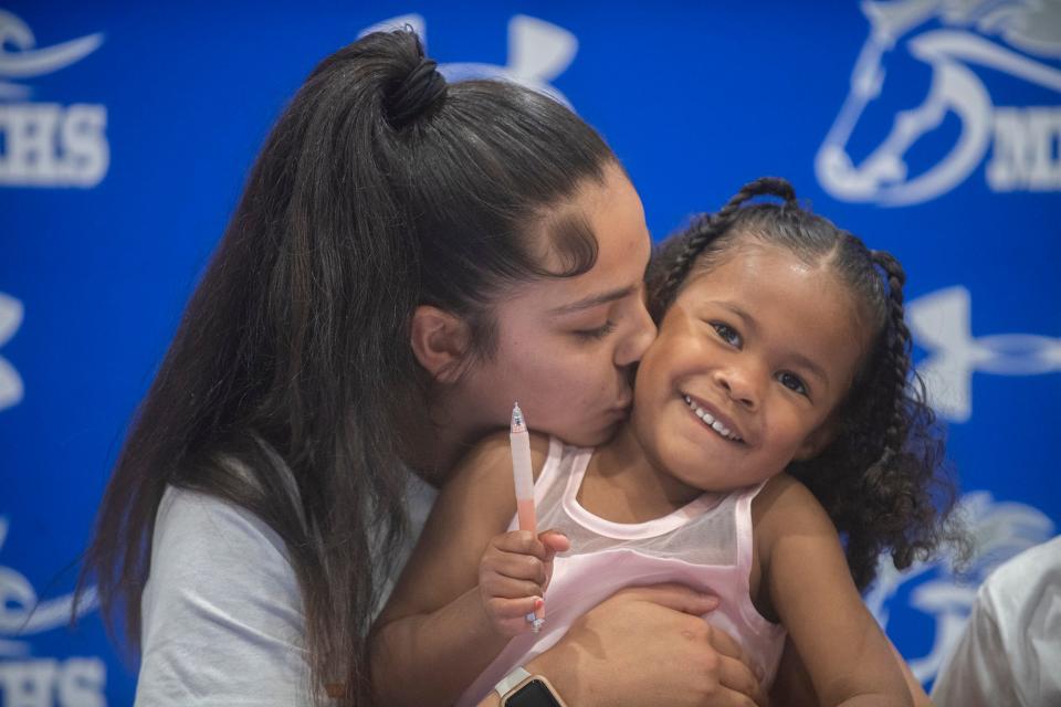 Mountain House girls basketball player Cayla Harang,kisses her daughter Royalty, 3, during her signing a letter if intent to play for the University of La Verne during a ceremony at the high school in Tracy on Wednesday, Apr. 12, 2023.