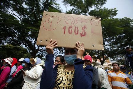 A garment worker holds a placard during a protest in central Phnom Penh in this December 31, 2013 file photo. REUTERS/Samrang Pring/Files