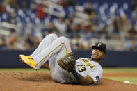 Pittsburgh Pirates third baseman Ke'Bryan Hayes (13) lies on the pitcher's mound after he fell while trying to catch a pop fly by Miami Marlins' Lewis Brinson, who ended up with a single during the ninth inning of a baseball game Saturday, Sept. 18, 2021, in Miami. The Pirates won 6-3. (AP Photo/Marta Lavandier)