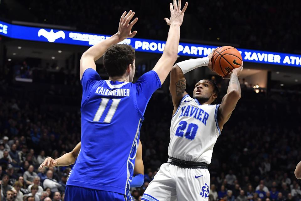 Xavier guard Dayvion McKnight (20) shoots over Creighton center Ryan Kalkbrenner (11) during the first half of an NCAA college basketball game in Cincinnati, Ohio, Saturday, Feb. 10, 2024. (AP Photo/Timothy D. Easley)