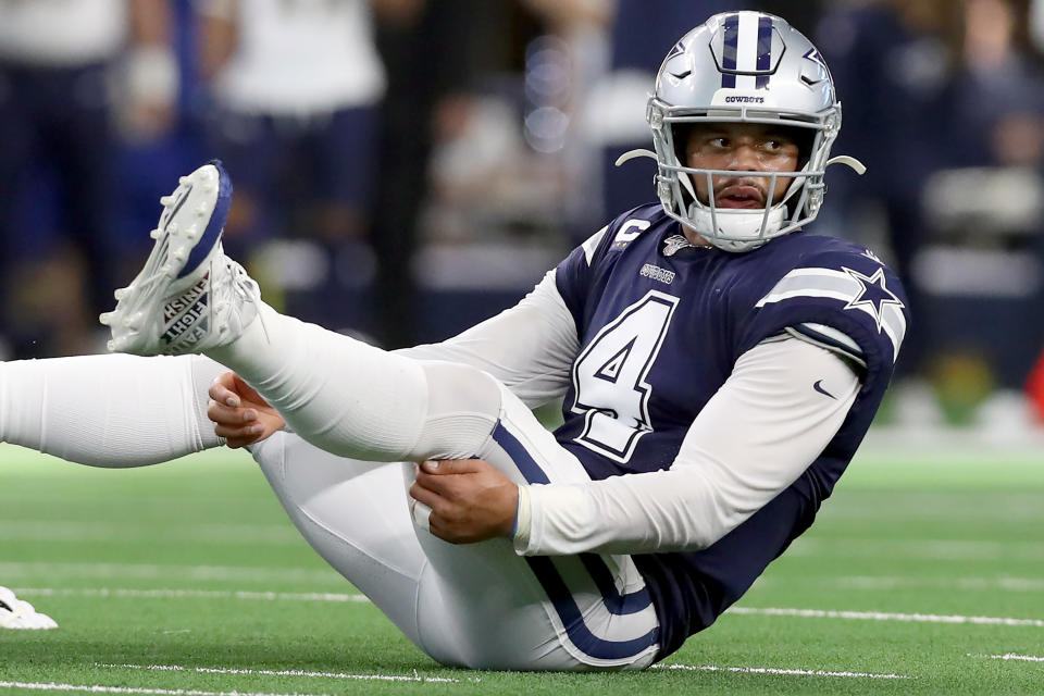 ARLINGTON, TEXAS - DECEMBER 15: Dak Prescott #4 of the Dallas Cowboys reacts after being knocked to the turf against the Los Angeles Rams in the first half at AT&T Stadium on December 15, 2019 in Arlington, Texas. (Photo by Tom Pennington/Getty Images)