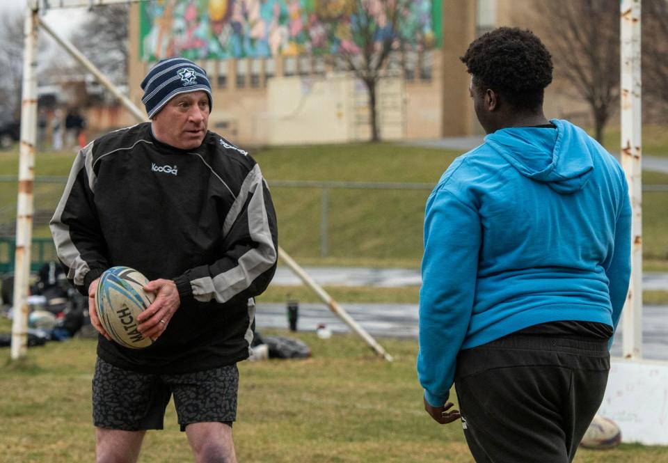 WORCESTER - Coach Bruce Mendelsohn works with Doherty High student Benjamin Asare during a drill at rugby practice Thursday, March 21, 2024.