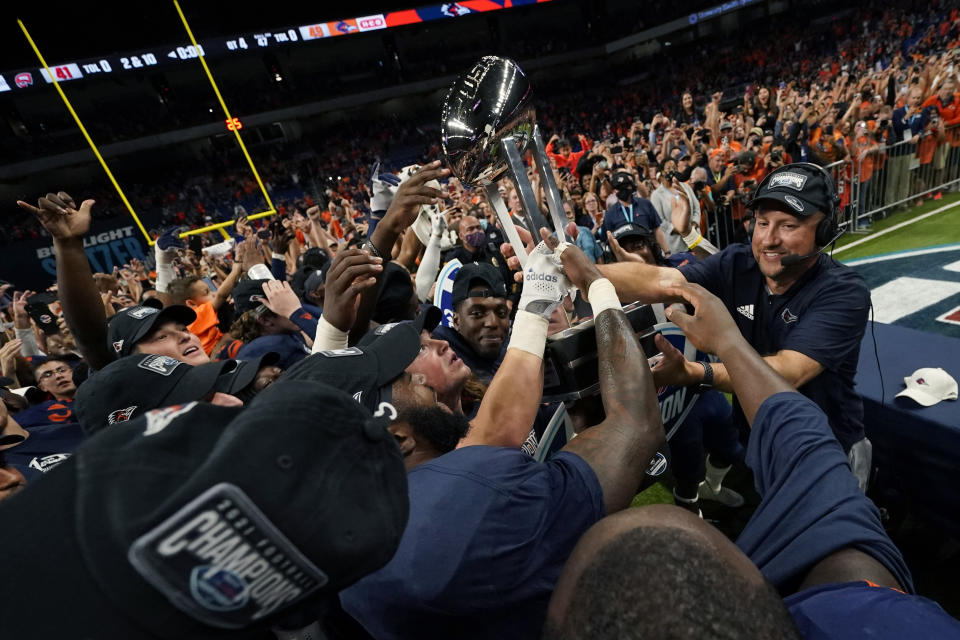 UTSA head coach Jeff Traylor, right, passes the championship trophy to his players after an NCAA college football game in the Conference USA Championship against Western Kentucky, Friday, Dec. 3, 2021, in San Antonio. (AP Photo/Eric Gay)