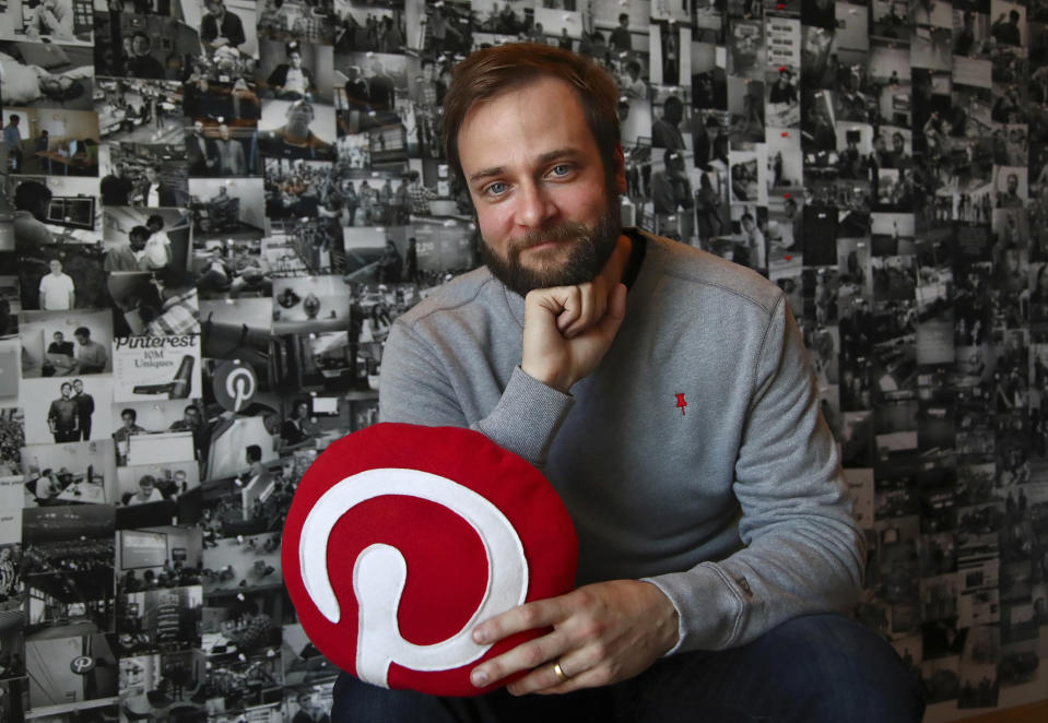 In this Thursday, Oct. 11, 2018, photo Evan Sharp, Pinterest co-founder and chief product officer, poses for a photo in his office beside a wall of pinned photos he has taken at Pinterest headquarters in San Francisco. “Social media is about sharing what you are doing with other people,” said Sharp. “Pinterest isn't about sharing. It's mostly about yourself, your dreams, your ideas you want for your future.” (AP Photo/Ben Margot)