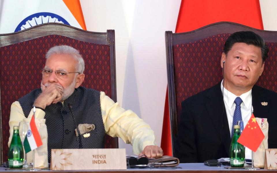 Indian Prime Minister Narendra Modi, left, and Chinese President Xi Jinping listen to a speech during the BRICS Leaders Meeting with the BRICS Business Council in Goa, India, last October - Credit: AP