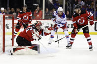 New Jersey Devils goaltender Akira Schmid, front left, makes a save in front of New York Rangers right wing Patrick Kane (88) during the third period of Game 7 of an NHL hockey Stanley Cup first-round playoff series Monday, May 1, 2023, in Newark, N.J (AP Photo/Adam Hunger)