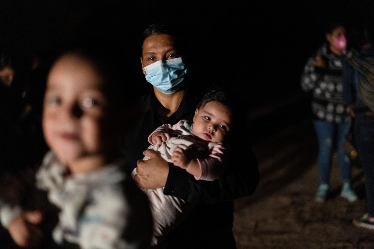 An asylum-seeking migrant mother holds her baby as she waits to be escorted by U.S. Border Patrols after crossing the Rio Grande river into the United States from Mexico in Roma, Texas, U.S., May 28, 2021. (Go Nakamura/Reuters)