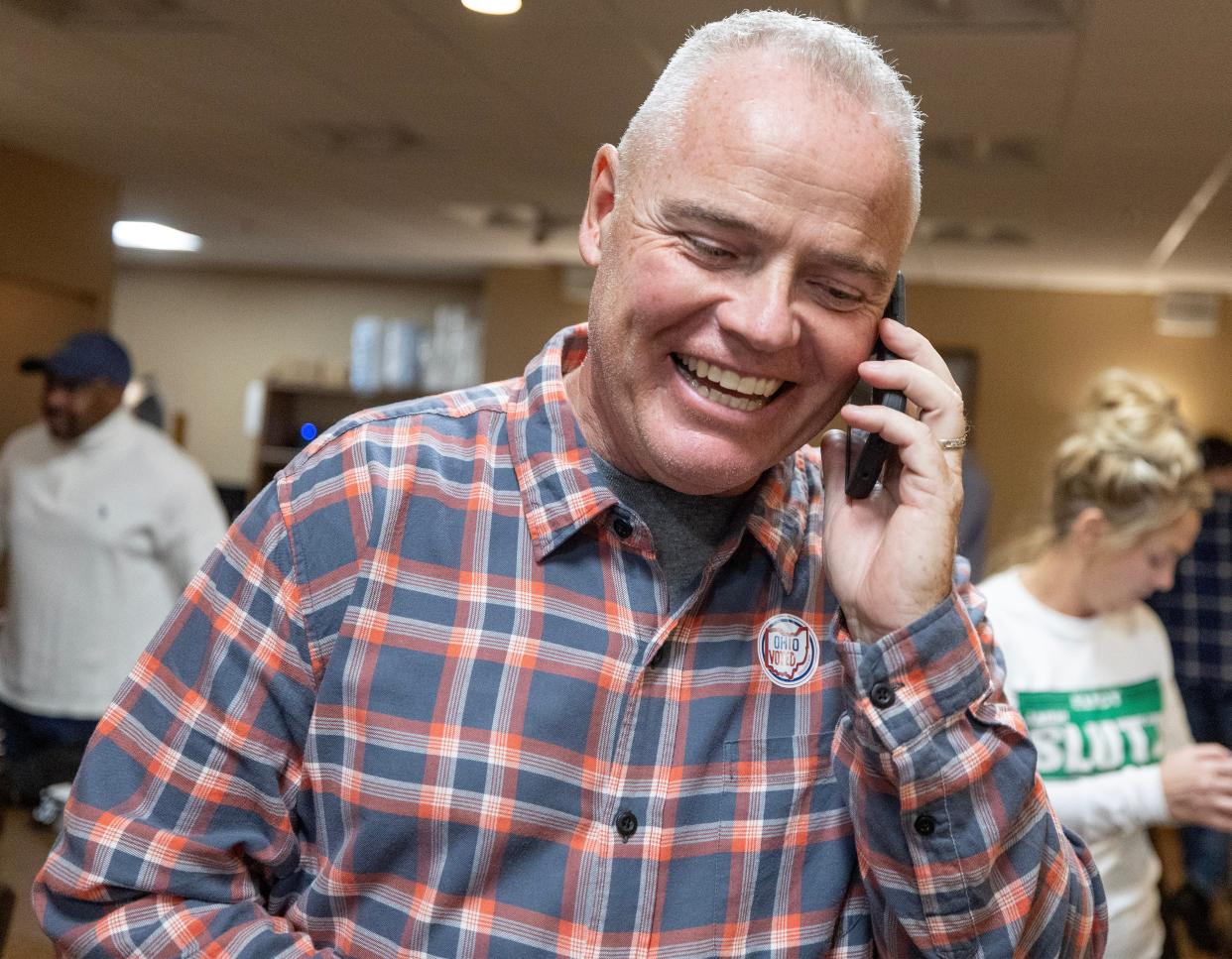 Massillon Mayor-elect Jamie Slutz takes a congratulatory call after he learns he won the election during a watch party at the Massillon Eagles Club.