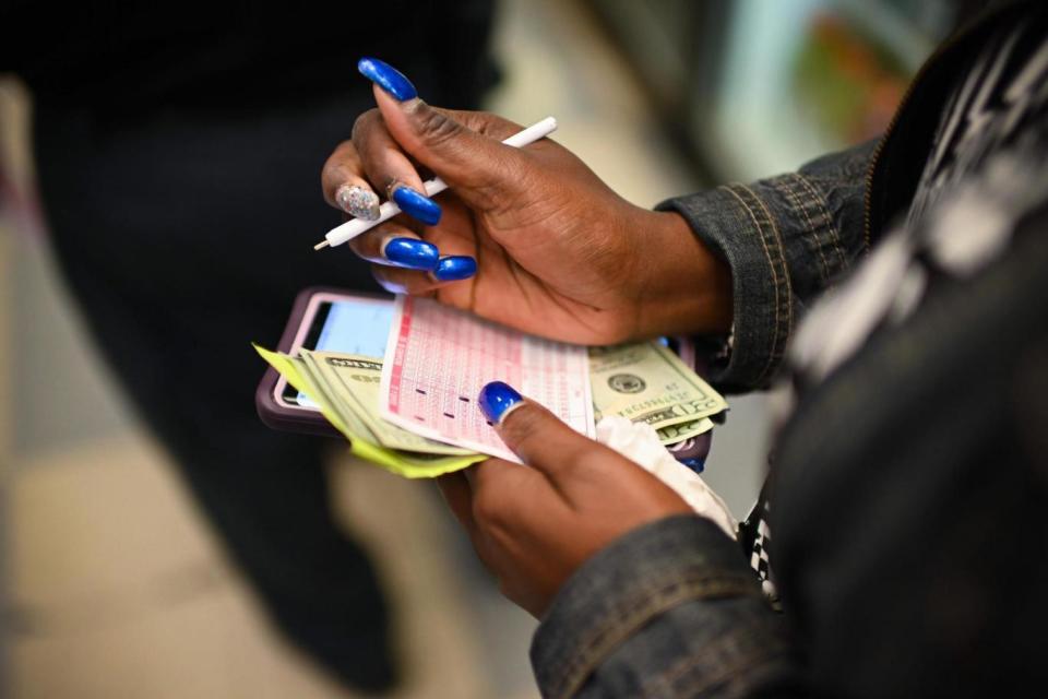 A woman buys Mega Millions tickets hours before the draw (AFP/Getty Images)