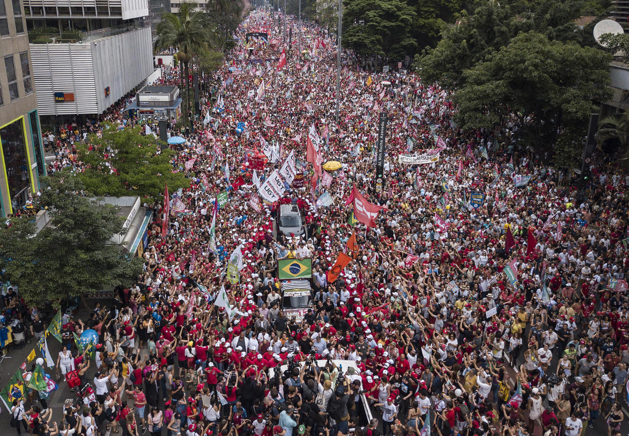 Supporters gather round a vehicle carrying former Brazilian President Luiz Inacio Lula da Silva during a campaign rally in Sao Paulo, Brazil, Saturday, Oct. 29, 2022. On Sunday, Brazilians head to the voting booth again to choose between da Silva and incumbent Jair Bolsonaro, who are facing each other in a runoff vote after neither got enough support to win outright in the Oct. 2 general election. (AP Photo/Matias Delacroix)