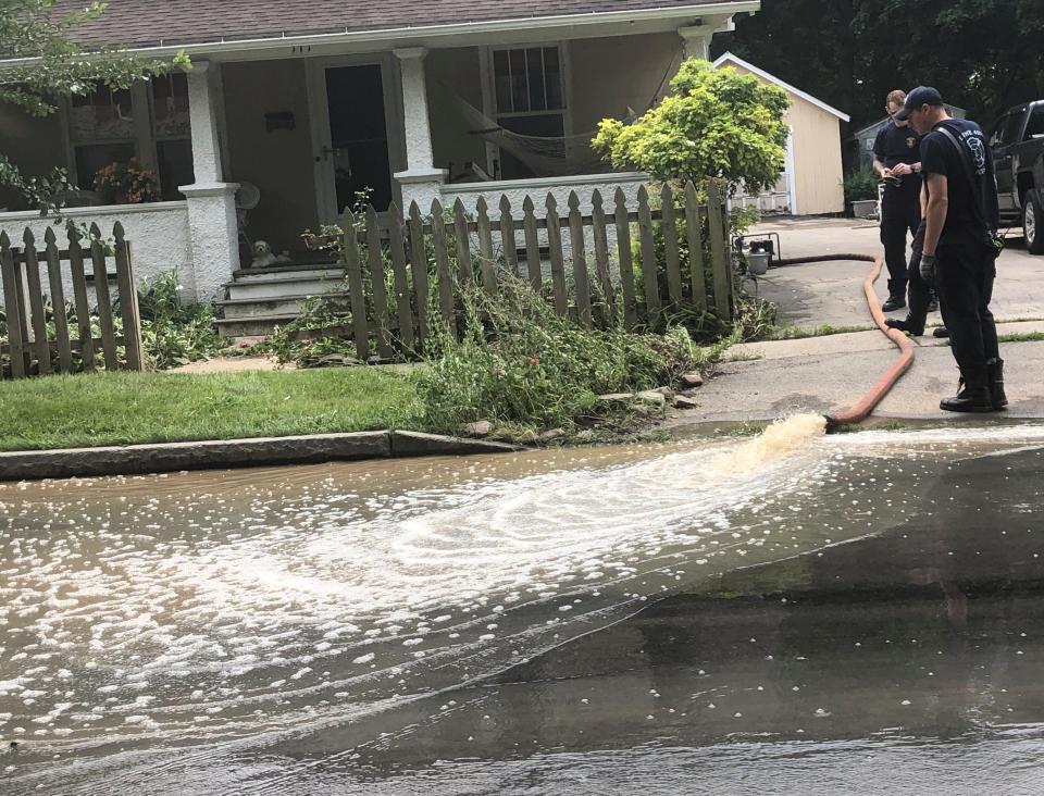 A familiar scene on West Gibson Street on Monday - water being pumped from basements after heavy rains Sunday.