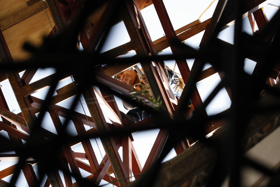 A worker picks his way across a steel frame at the base of the damaged cupola, during the early stages of reconstruction work at Nuestra Senora de Los Angeles, Our Lady of Angels church, three years after an earthquake collapsed nearly half of its 18th-century dome in Mexico City, Tuesday, Oct. 6, 2020. Restorers said they realized that the cause of the collapse had been an enormously heavy central cupola that stood atop the dome and which had been leaning out of level because the church was unevenly sinking into Mexico City’s notoriously swampy soil. So the collapsed part could be rebuilt and mated with the remaining structure. (AP Photo/Rebecca Blackwell)