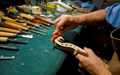 More than 70 pieces of wood are used to make violins and other instruments by craftsmen in Cremona - Credit: Getty