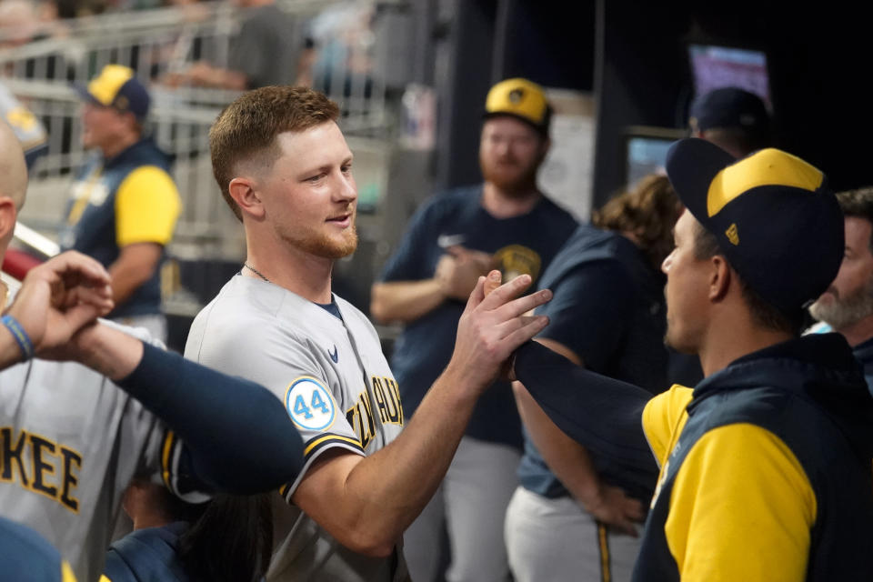 Milwaukee Brewers starting pitcher Eric Lauer, left, celebrates in the dugout with teammates after being relieved in the seventh inning of a baseball game against the Atlanta Braves, Friday, May 6, 2022, in Atlanta. (AP Photo/John Bazemore)