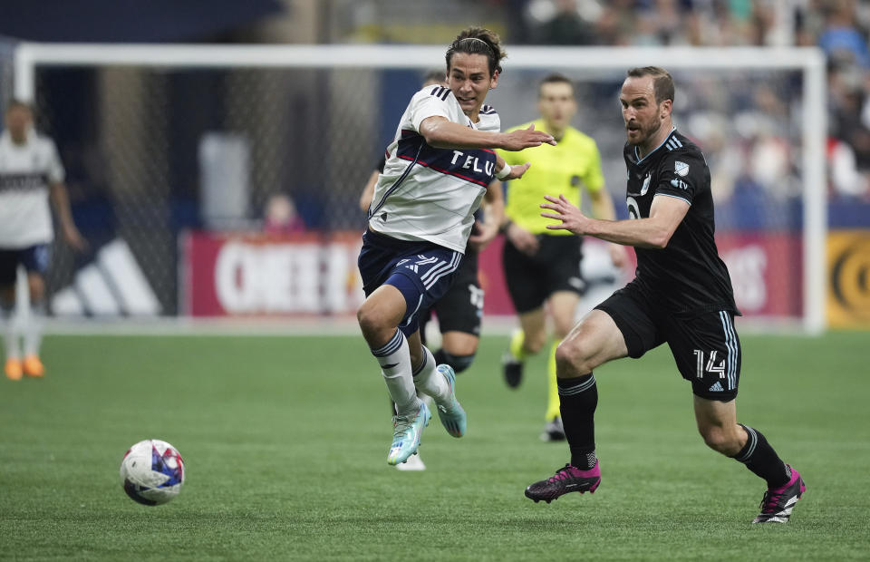 Vancouver Whitecaps' Simon Becher, left, and Minnesota United's Brent Kallman vie for the ball during the second half of an MLS soccer match in Vancouver, British Columbia, Saturday, May 6, 2023. (Darryl Dyck/The Canadian Press via AP)