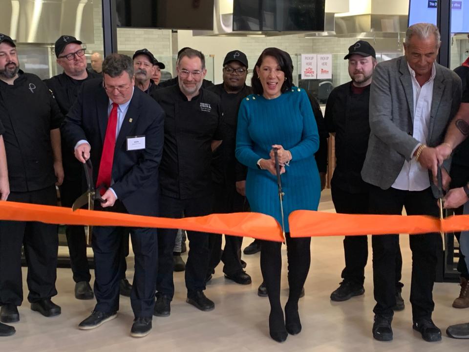 Cincinnati vice mayor, Jan-Michele Kearney, helps cut the ribbon for the grand opening of Atrium Food Market