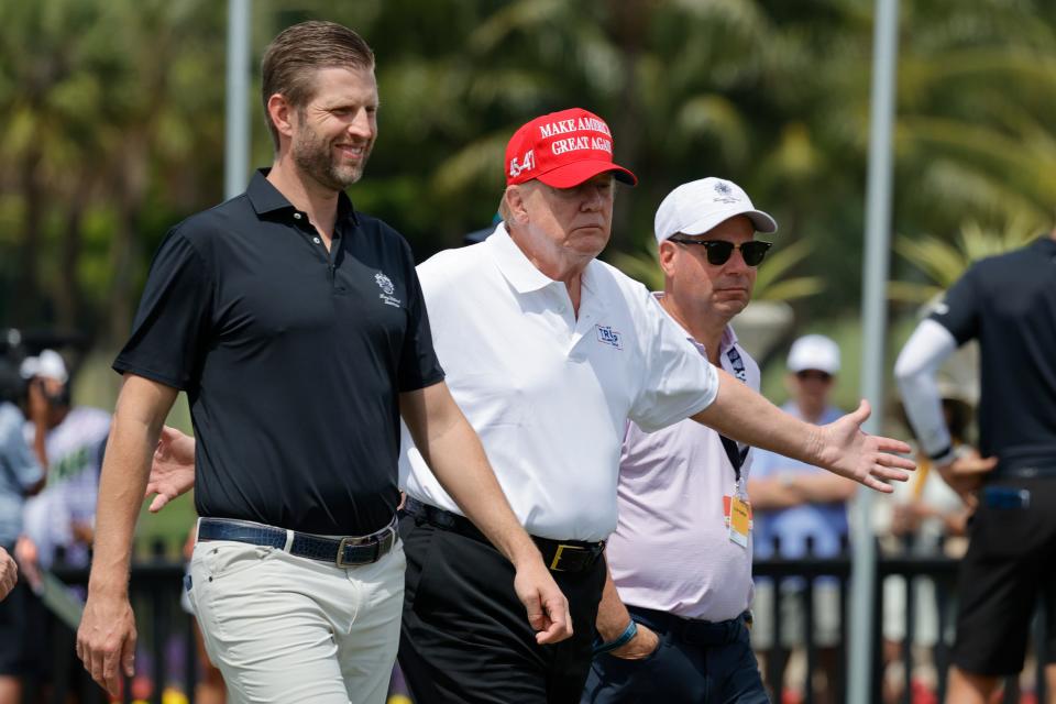 Apr 7, 2024; Miami, Florida, USA; Donald Trump, middle, and his son Eric, left, along with Larry Glick, right, of Trump Resort greet golfers on the practice green before the final round of LIV Golf Miami golf tournament at Trump National Doral. Mandatory Credit: Reinhold Matay-USA TODAY Sports