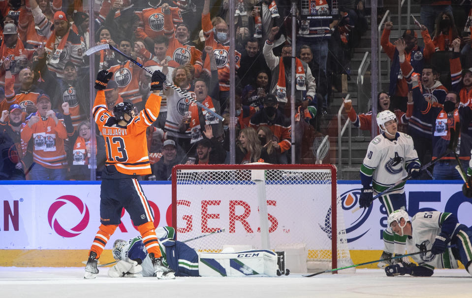 Vancouver Canucks goalie Thatcher Demko, lying on ice, gives up a goal to Edmonton Oilers' Jesse Puljujarvi (13) during the first period of an NHL hockey game Wednesday, Oct. 13, 2021, in Edmonton, Alberta. (Jason Franson/The Canadian Press via AP)