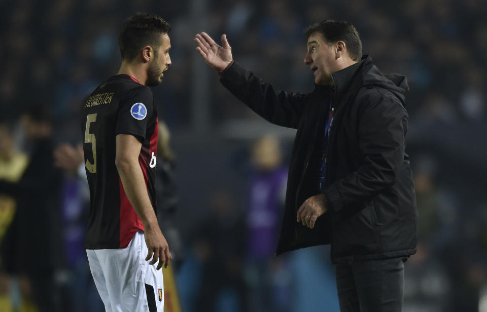 Coach Nestor Lorenzo of Peru's Melgar, right talks to his defender Alec Deneumostier during a Copa Sudamericana soccer match against Argentina's Racing Club at Presidente Peron stadium in Buenos Aires, Argentina, Wednesday, May 18, 2022. (AP Photo/Gustavo Garello)