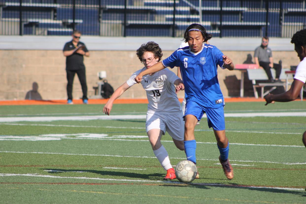 Camilo Trujillo-Pablo of Woodville-Tompkins rolls past a Temple defender in the Wolverine's playoff win on April 25, 2024.